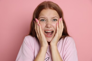 Photo of Teenage girl suffering from panic attack on pink background