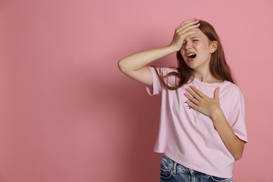 Photo of Teenage girl suffering from panic attack on pink background. Space for text
