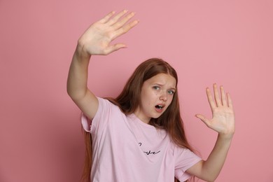 Photo of Teenage girl suffering from panic attack on pink background