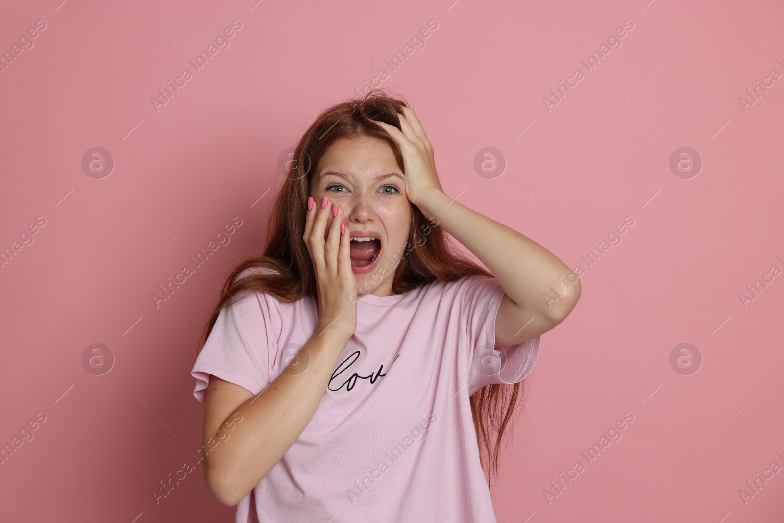 Photo of Teenage girl suffering from panic attack on pink background