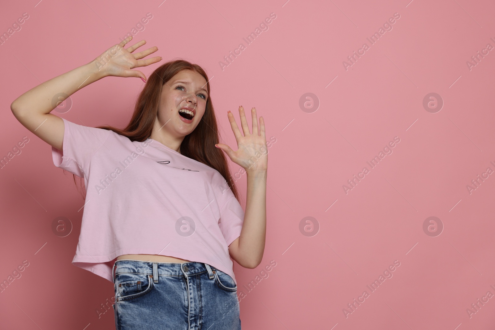 Photo of Teenage girl suffering from panic attack on pink background