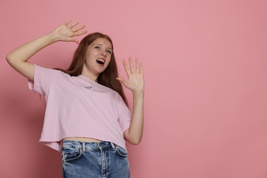 Photo of Teenage girl suffering from panic attack on pink background