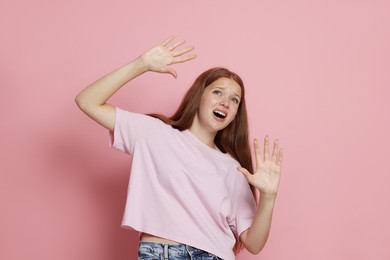 Photo of Teenage girl suffering from panic attack on pink background