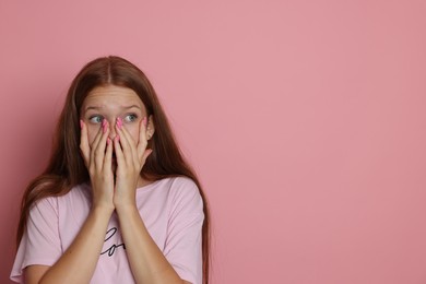 Photo of Teenage girl suffering from panic attack on pink background. Space for text