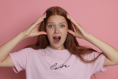 Photo of Teenage girl suffering from panic attack on pink background