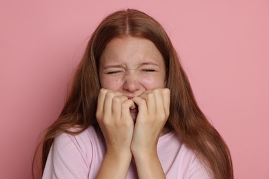 Photo of Teenage girl suffering from panic attack on pink background