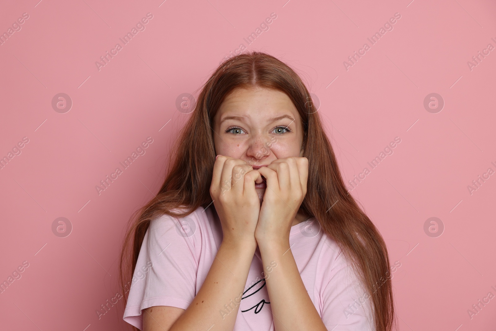 Photo of Teenage girl suffering from panic attack on pink background