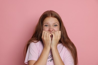 Photo of Teenage girl suffering from panic attack on pink background