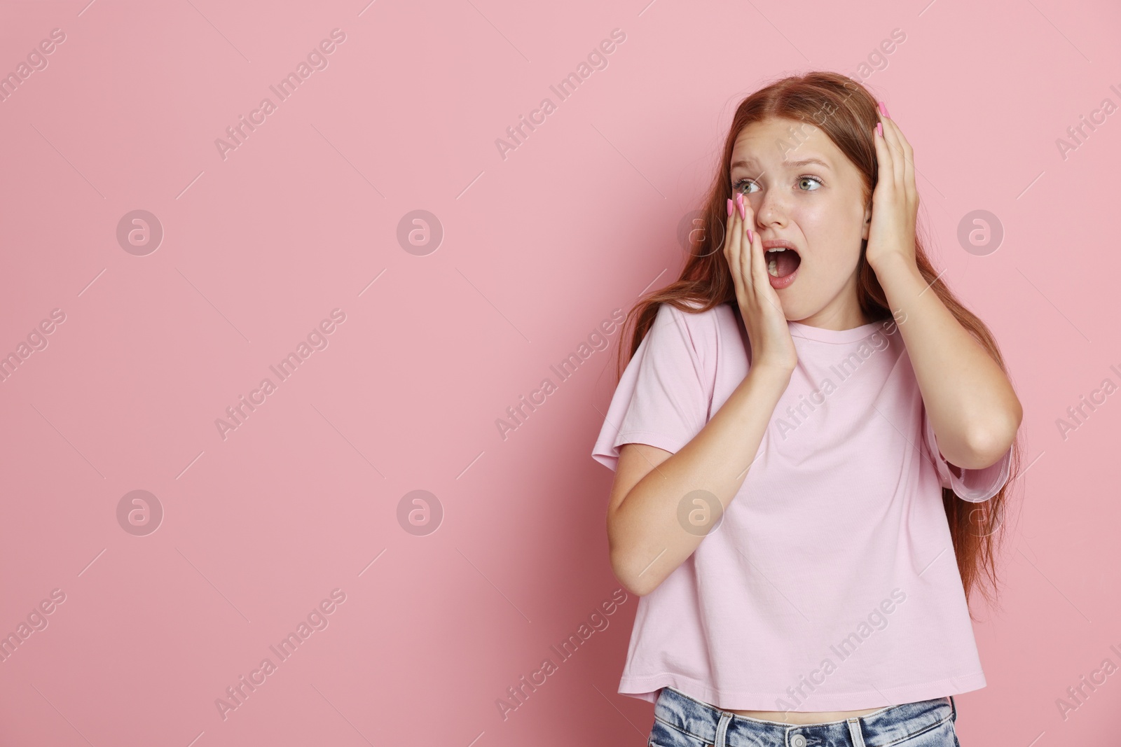 Teenage girl suffering from panic attack on pink background. Space for text Photo of Teenage girl suffering from panic attack on pink background. Space for text