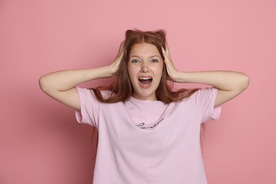 Photo of Teenage girl suffering from panic attack on pink background