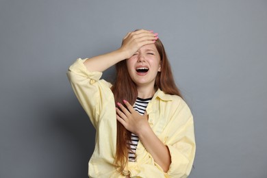 Photo of Teenage girl suffering from panic attack on grey background