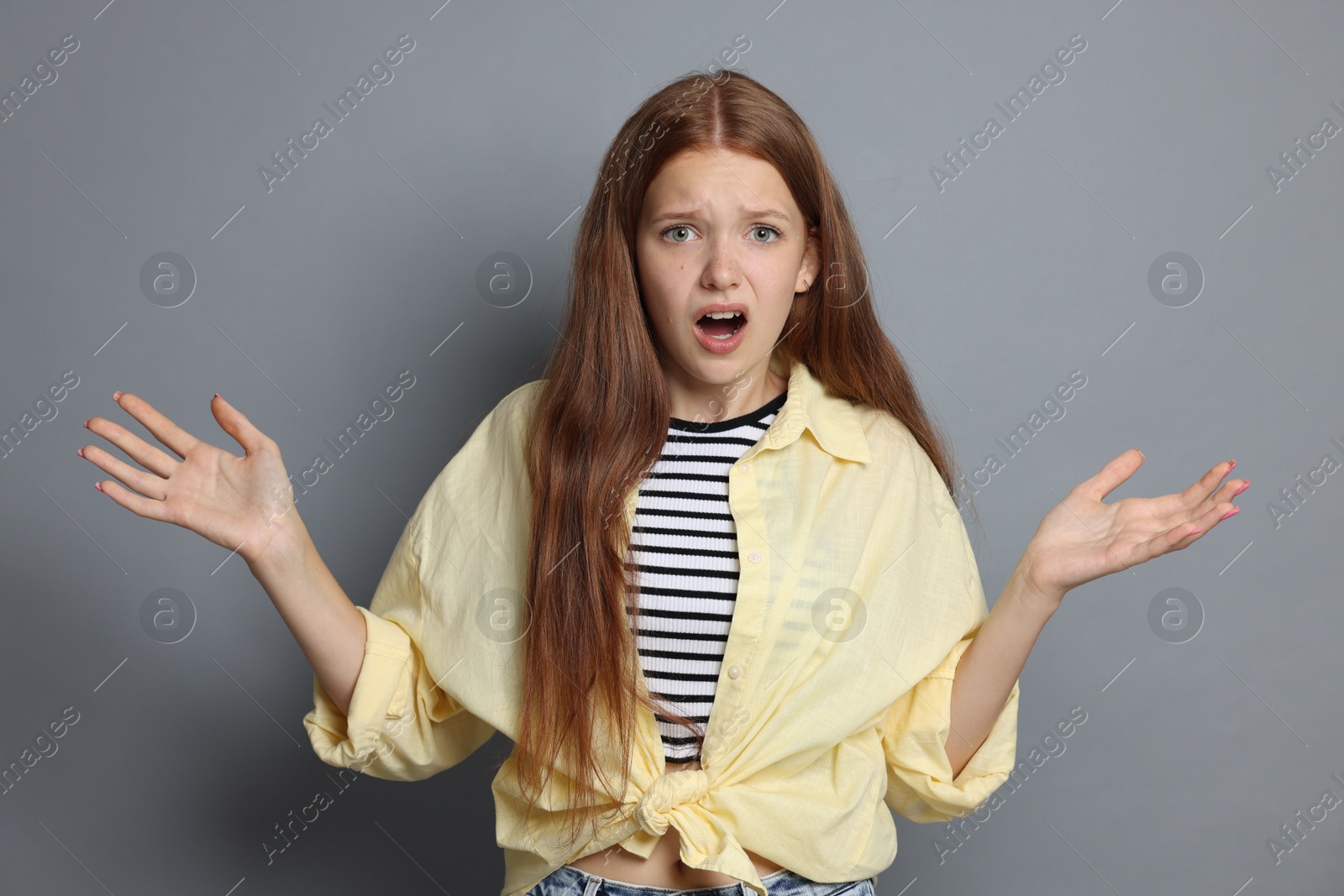 Teenage girl suffering from panic attack on grey background Photo of Teenage girl suffering from panic attack on grey background