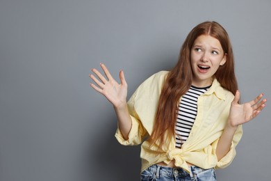 Photo of Teenage girl suffering from panic attack on grey background. Space for text