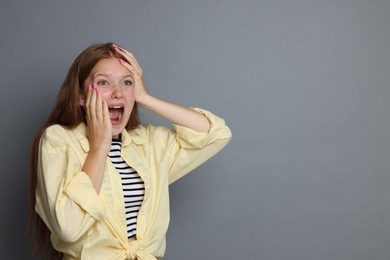 Photo of Teenage girl suffering from panic attack on grey background. Space for text