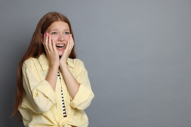 Photo of Teenage girl suffering from panic attack on grey background. Space for text