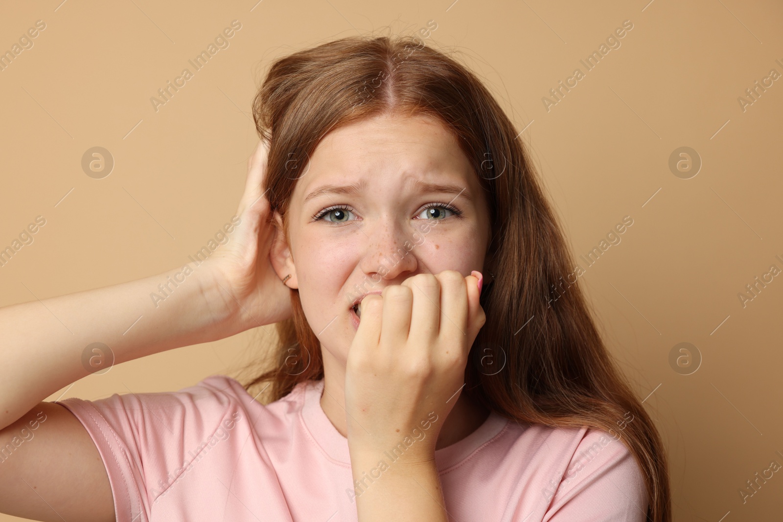 Teenage girl suffering from panic attack on beige background Photo of Teenage girl suffering from panic attack on beige background