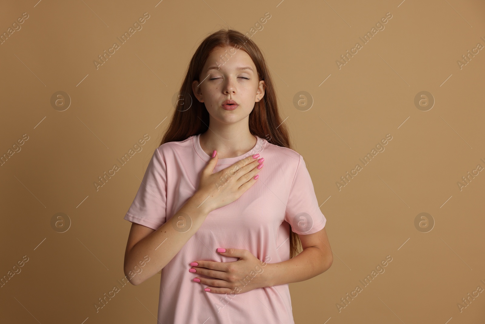 Teenage girl deep breathing on beige background. Way to stop panic attack Photo of Teenage girl deep breathing on beige background. Way to stop panic attack