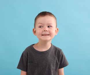 Photo of Portrait of smiling boy on light blue background
