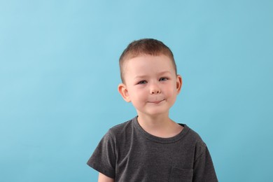 Photo of Portrait of smiling boy on light blue background
