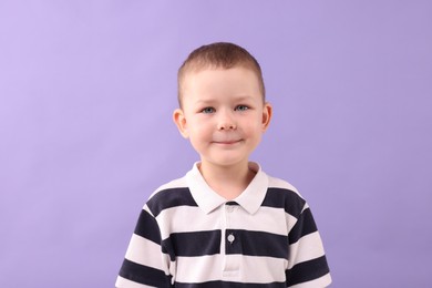 Photo of Portrait of smiling boy on violet background
