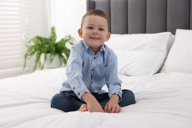 Photo of Smiling little boy on bed at home