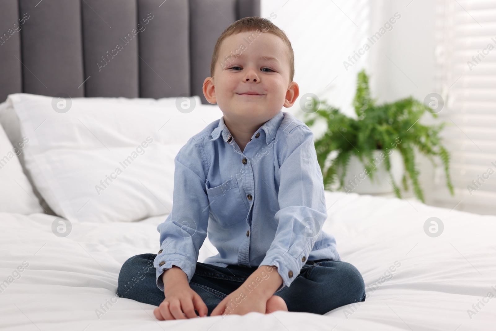 Smiling little boy on bed at home Photo of Smiling little boy on bed at home