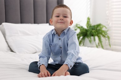 Photo of Smiling little boy on bed at home