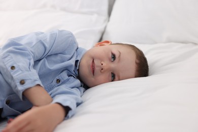 Photo of Smiling little boy on bed at home