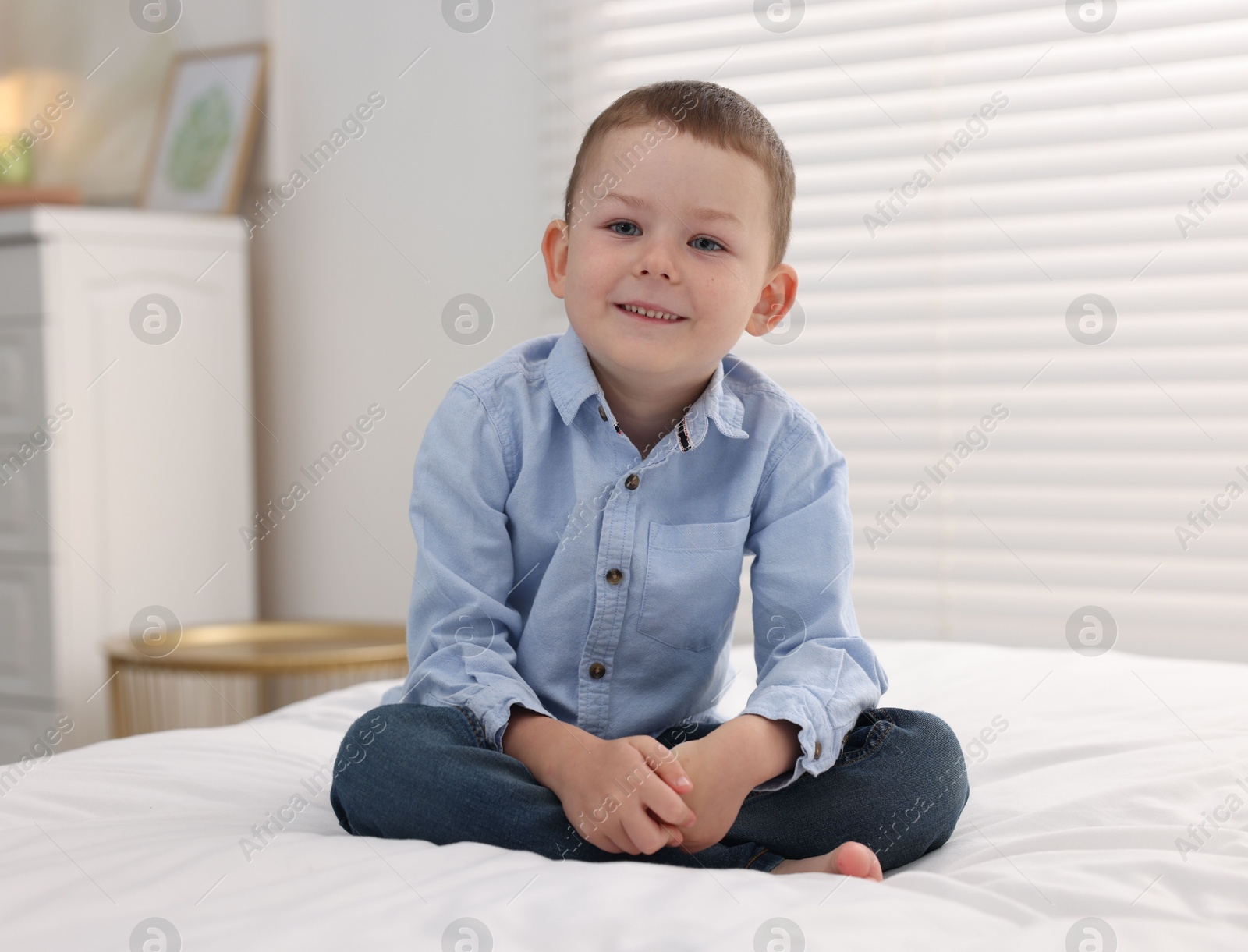 Smiling little boy on bed at home Photo of Smiling little boy on bed at home