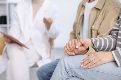 Photo of In vitro fertilization (IVF). Couple holding hands during appointment with doctor in reproductive clinic, closeup