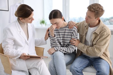 Photo of In vitro fertilization (IVF). Doctor supporting upset couple during visit in reproductive clinic