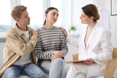 Photo of In vitro fertilization (IVF). Doctor supporting upset couple during visit in reproductive clinic