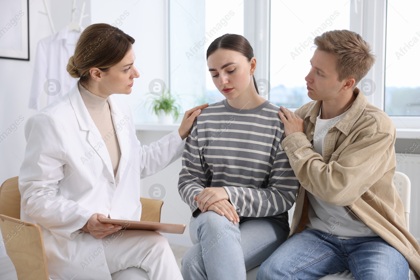 Photo of In vitro fertilization (IVF). Doctor supporting upset couple during visit in reproductive clinic