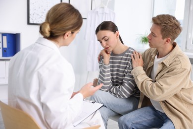 Photo of In vitro fertilization (IVF). Upset couple having appointment with doctor in reproductive clinic