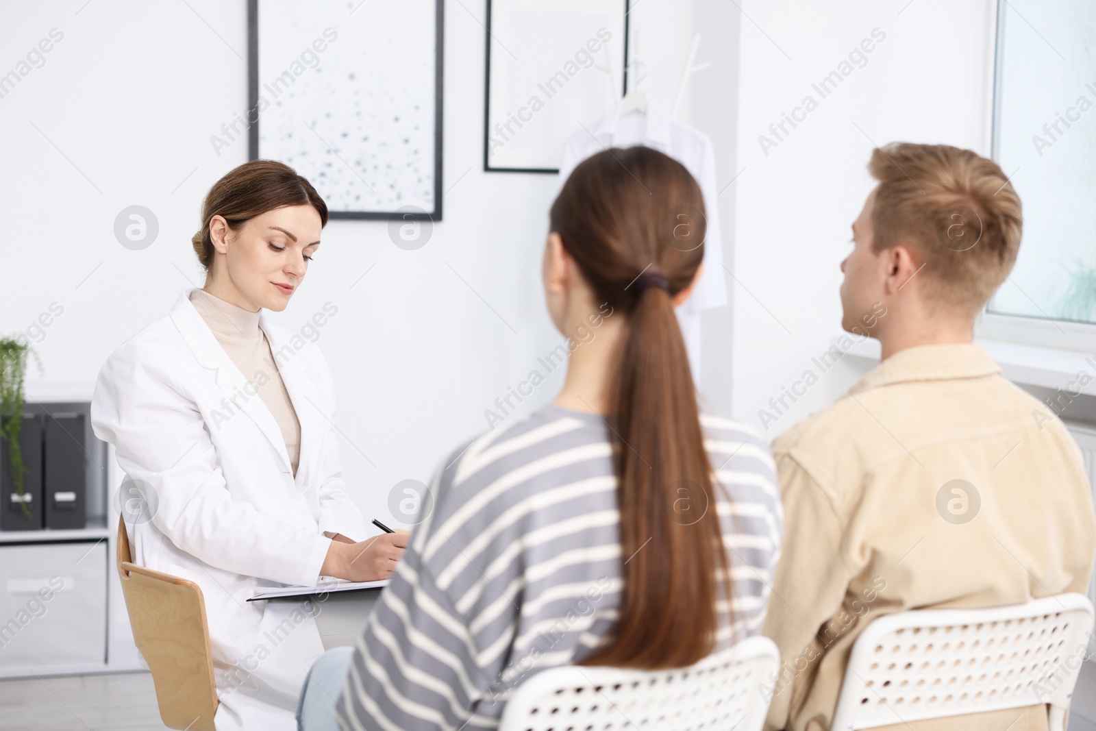 In vitro fertilization (IVF). Couple having appointment with doctor in reproductive clinic Photo of In vitro fertilization (IVF). Couple having appointment with doctor in reproductive clinic