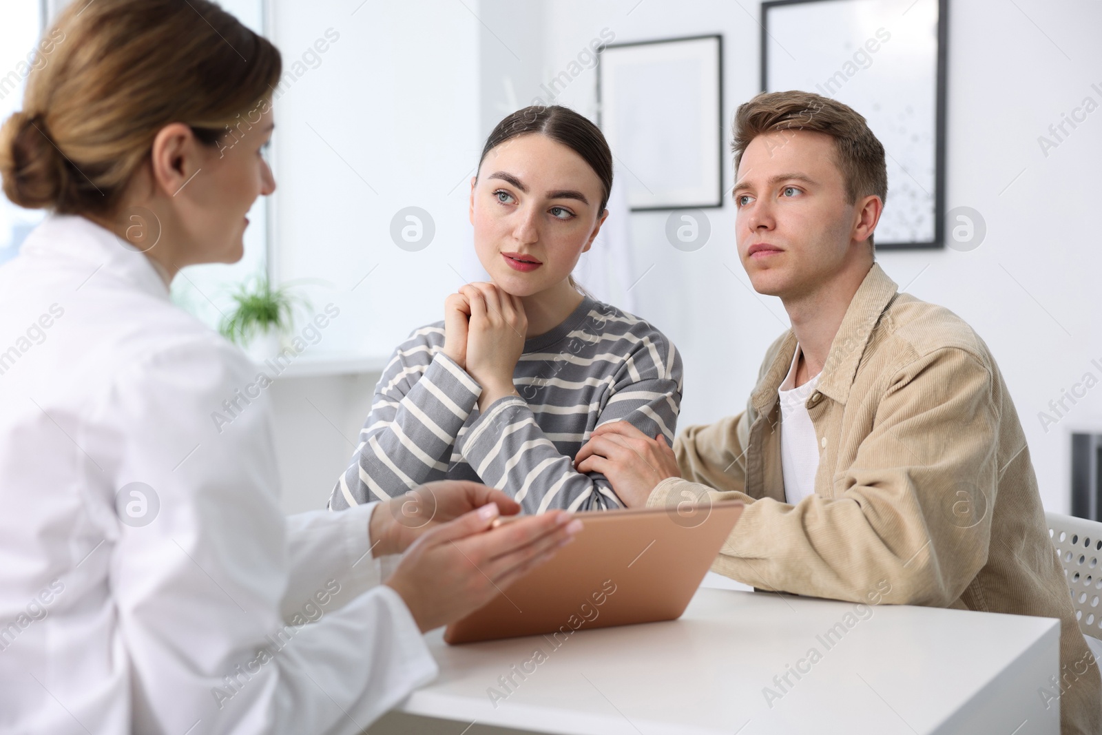 In vitro fertilization (IVF). Couple having appointment with doctor in reproductive clinic Photo of In vitro fertilization (IVF). Couple having appointment with doctor in reproductive clinic