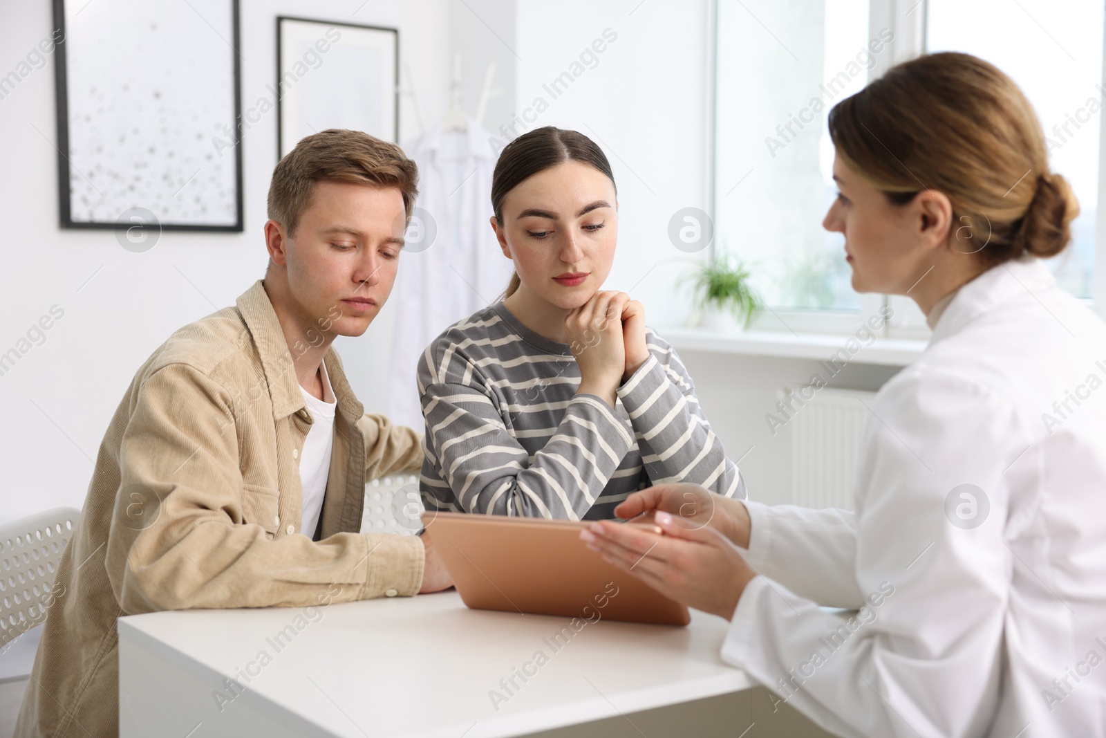 In vitro fertilization (IVF). Couple having appointment with doctor in reproductive clinic Photo of In vitro fertilization (IVF). Couple having appointment with doctor in reproductive clinic