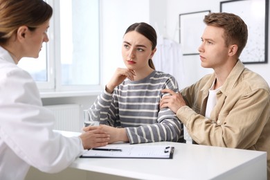 Photo of In vitro fertilization (IVF). Doctor supporting upset couple during visit in reproductive clinic