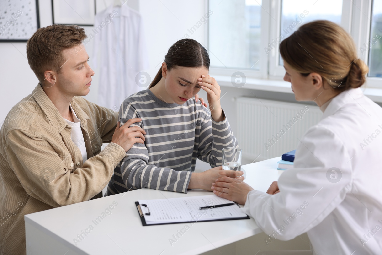 Photo of In vitro fertilization (IVF). Doctor supporting upset couple during visit in reproductive clinic