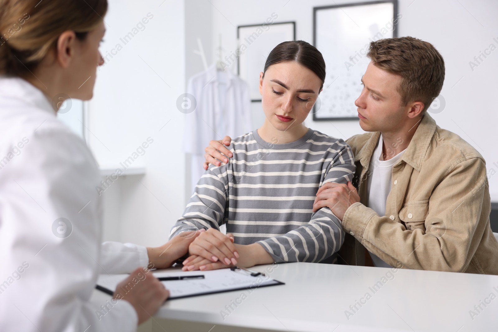 Photo of In vitro fertilization (IVF). Doctor supporting upset couple during visit in reproductive clinic