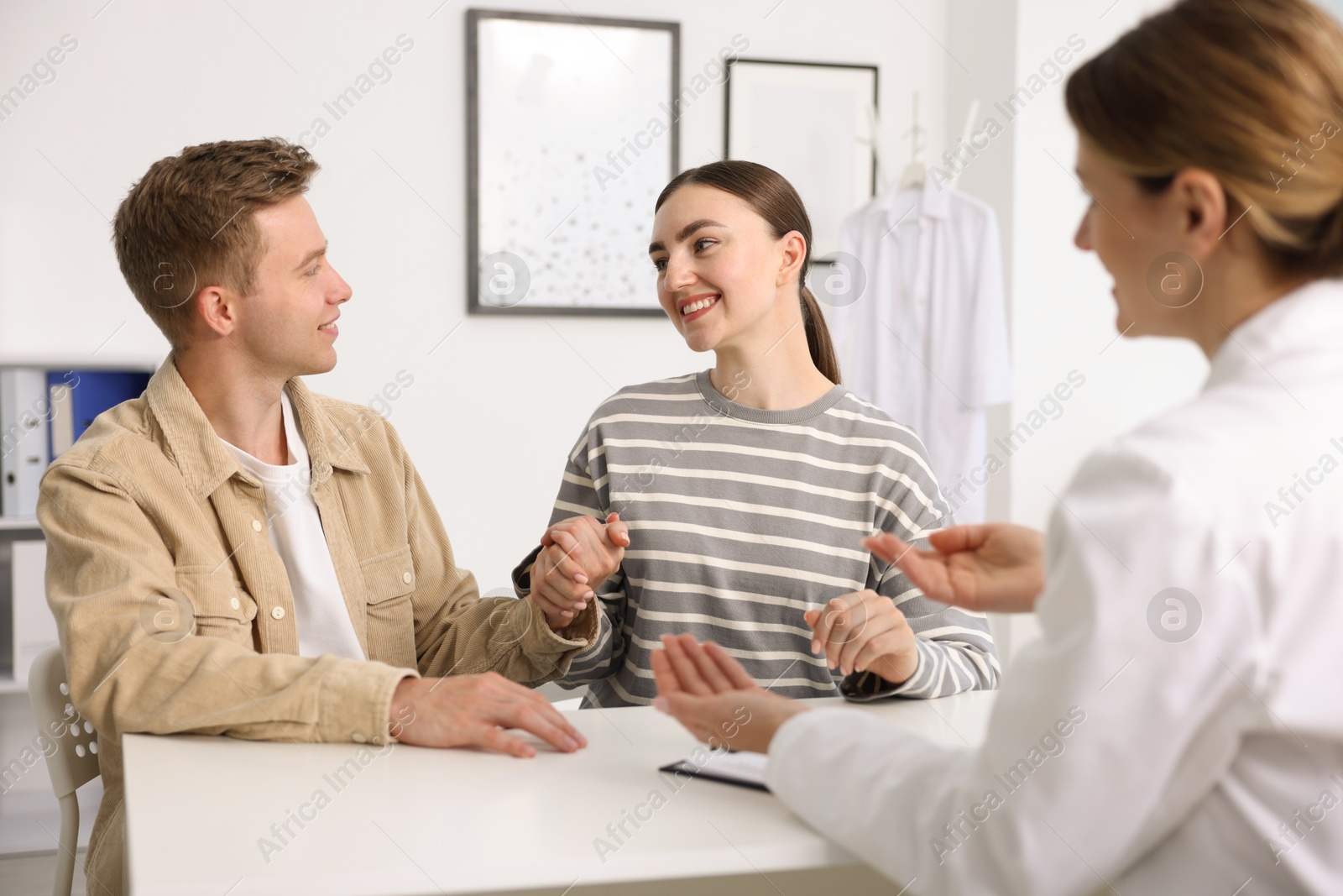 In vitro fertilization (IVF). Couple holding hands during appointment with doctor in reproductive clinic Photo of In vitro fertilization (IVF). Couple holding hands during appointment with doctor in reproductive clinic