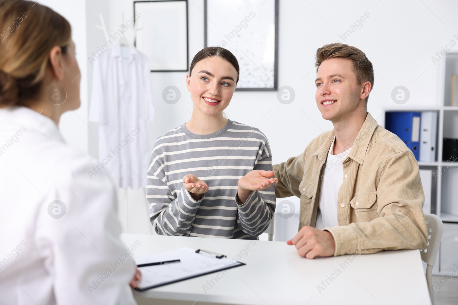 Photo of In vitro fertilization (IVF). Happy couple having appointment with doctor in reproductive clinic