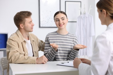 Photo of In vitro fertilization (IVF). Happy couple having appointment with doctor in reproductive clinic