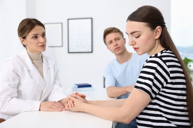 Photo of In vitro fertilization (IVF). Doctor supporting upset couple during visit in reproductive clinic