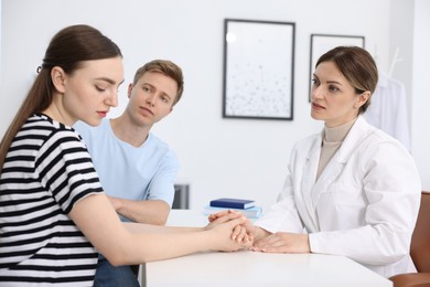 Photo of In vitro fertilization (IVF). Doctor supporting upset couple during visit in reproductive clinic