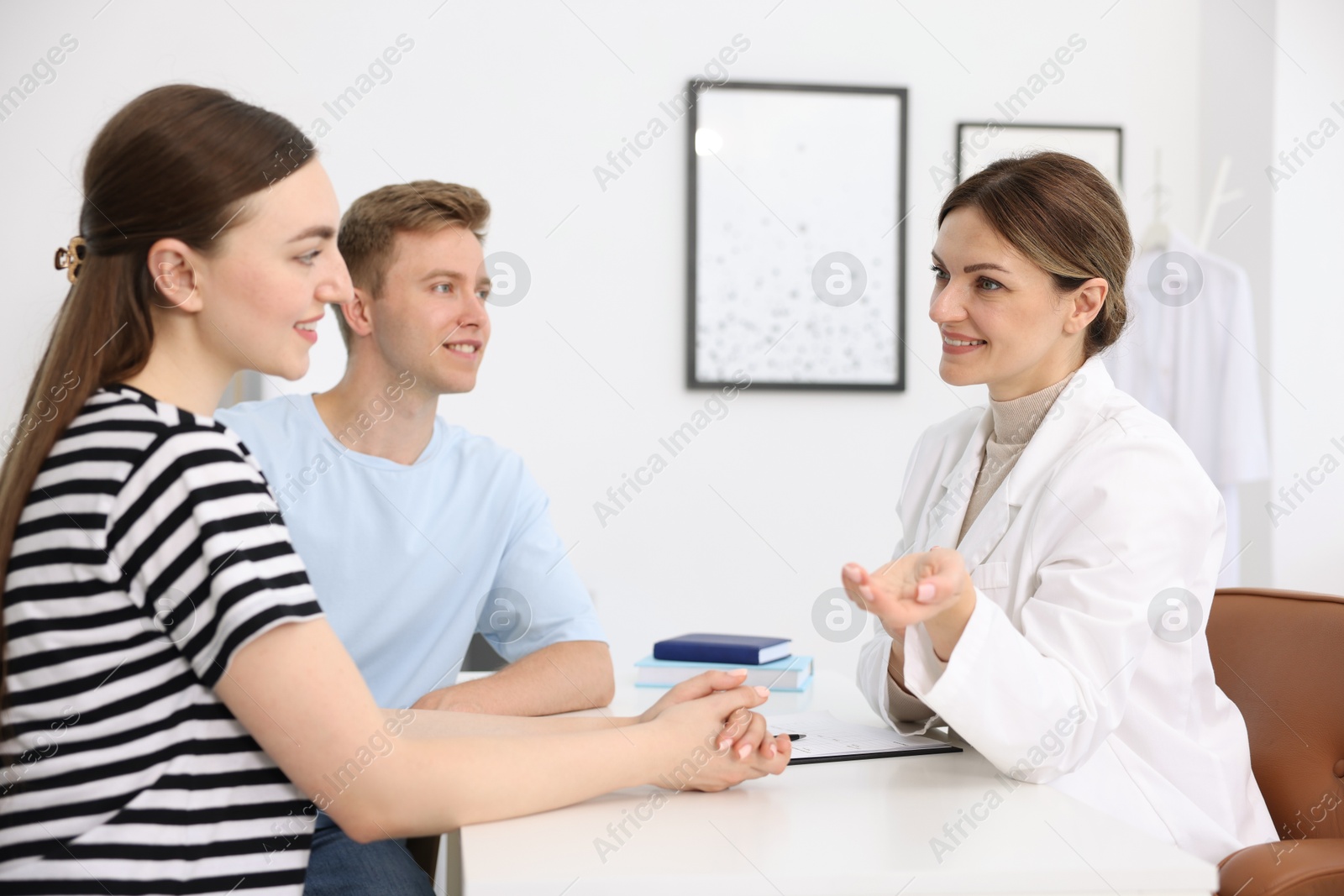 Photo of In vitro fertilization (IVF). Happy couple having appointment with doctor in reproductive clinic
