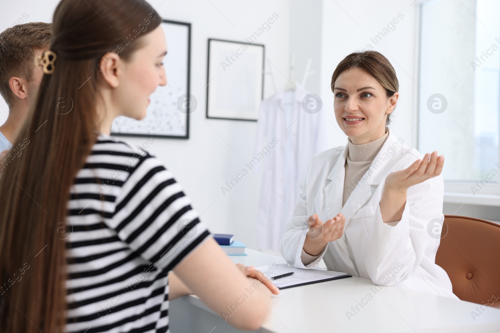 Photo of In vitro fertilization (IVF). Happy couple having appointment with doctor in reproductive clinic