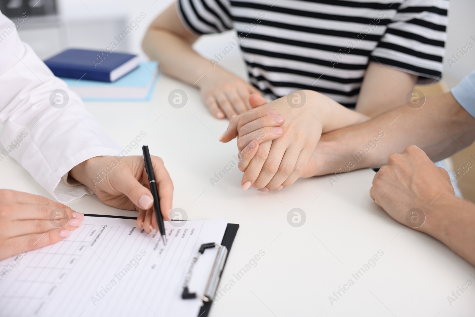 In vitro fertilization (IVF). Couple holding hands during appointment with doctor in reproductive clinic, closeup Photo of In vitro fertilization (IVF). Couple holding hands during appointment with doctor in reproductive clinic, closeup