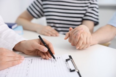 Photo of In vitro fertilization (IVF). Couple holding hands during appointment with doctor in reproductive clinic, closeup