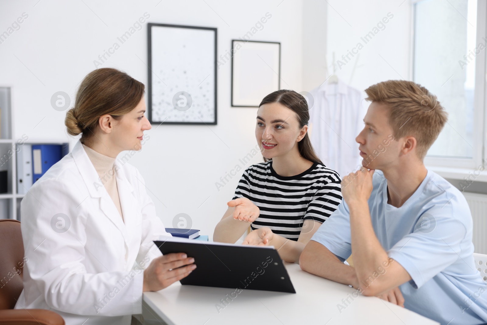 In vitro fertilization (IVF). Couple having appointment with doctor in reproductive clinic Photo of In vitro fertilization (IVF). Couple having appointment with doctor in reproductive clinic